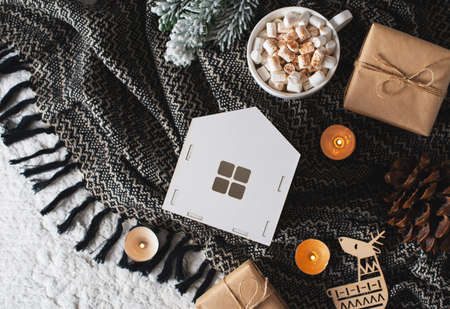 White toys house, hot chocolate with marshmallows and craft paper gift on black blanket, top view, copy spaceの写真素材