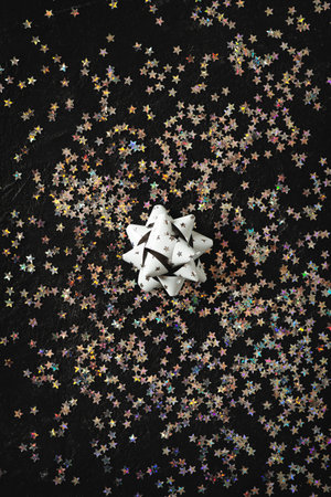 Single silver bow close up with shimmer on black background, top view, copy space, verticalの写真素材
