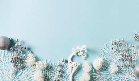 Merry christmas and happy new year card flat lay with silver and white branch on blue background, top view, copy spaceの写真素材