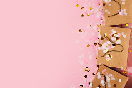 Valentine and mothers day concept with craft package with pink bow and confetti, top view, copy space, flat layの写真素材