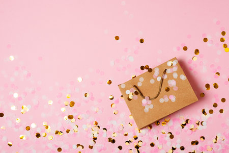 Valentine and mothers day concept with craft package with pink bow and confetti, top view, copy space, flat layの写真素材