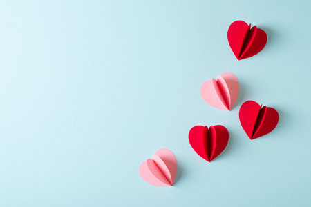 Red and pink paper hearts valentine or mothers day concept flat lay on blue background, copy space, top viewの写真素材