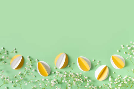 Yellow paper crafting eggs on green background, easter and spring conceptの写真素材