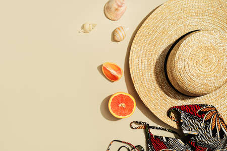 Travel and vacation concept flat lay with orange cocktail aperol and hat on yellow background