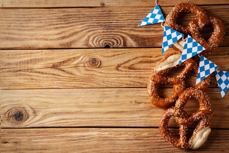 concept with pretzel and blue simbol flag on wood background, copy space, top view, flat lay, borderの写真素材