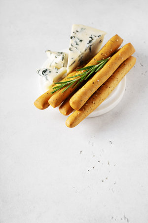 Grissini with blue cheese, bread stick, italian traditional cuisine close up on white background, top view, verticalの写真素材