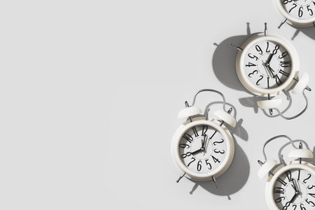 Few white alarm clocks on empty white background, minimalism concept sleep, education, time, banner,...