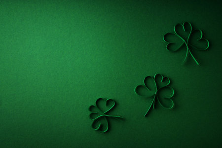 Saint Patrick day flat lay concept with paper shamrock clover on green background, top view, copy spaceの写真素材
