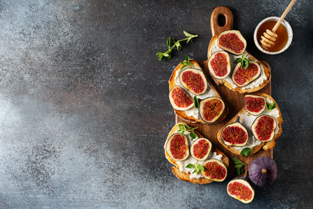 Fig bruschetta, bread and cream cheese and fruit on dark background, close up, top view, copy spaceの写真素材