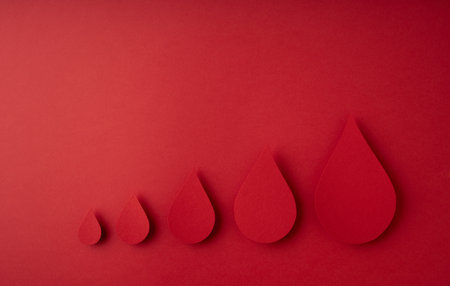 World donor day concept with paper red drop on red background, top view. copy spaceの写真素材