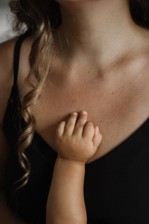 Kids, newborn baby hand on mothers breast close up, concept of love, care, childhood, parenthood, mothers day, lifestyleの写真素材