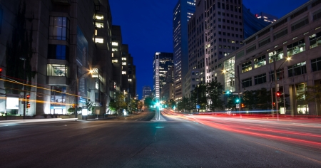 University Street in Montreal with silhouette cars with red rear light and traffic light, early...