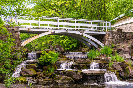 Small waterfall with a footbridge over the falls in Montreal,Quebec,Canada Small waterfall with a footbridge over the falls in Montreal,Quebec,Canada