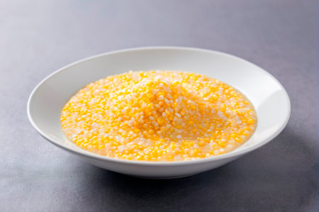 Creamy Corn Porridge in Bowl on Gray Background. Generative AI.