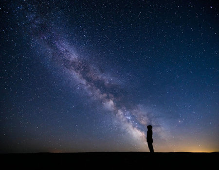 Silhouette of a man watching the milky way at nightの写真素材