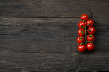 Bunch of ripe delicious red cherry tomatoes close-up on wooden backgroundの写真素材