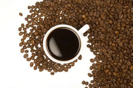 Cup of hot aromatic coffee with coffee grains isolated top view. Coffee background.