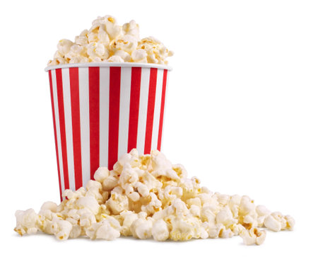 Popcorn in a striped bucket and a handful of popcorn flakes isolated on a white background.の写真素材