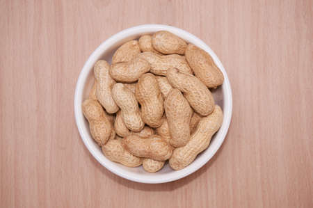 Peanuts with a brownish background of light wood.の写真素材