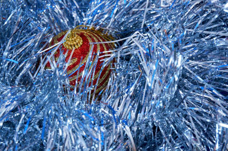 Red Christmas toy with gold stripes on a blue background close-up. New Year, christmas background.の写真素材