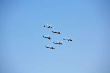 Five military helicopter on a blue sky background.