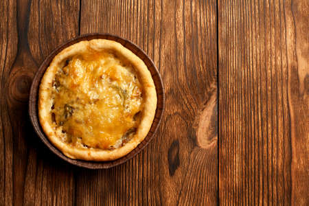 Mini Pizzas - Fresh homemade mini pizzas with pepperoni, cheese, tomatoes and basil on rustic wooden background with copy space.の写真素材