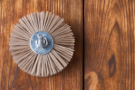 Grinding brush nylon for a drill for wood, on a wood background