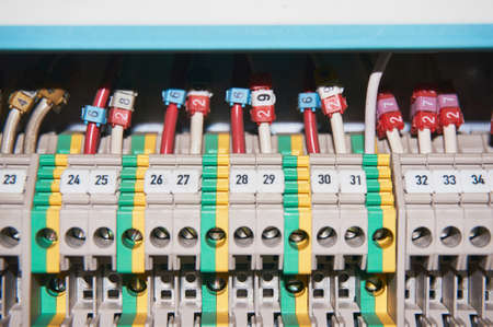 Many intermediate relays installed in a row. They are connected with many wires red with marking....