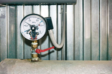 A pressure gauge with electrical contacts and a connected wire.の写真素材
