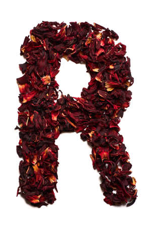 English alphabet. Letter R from dried flowers of hibiscus tea on a white background. Letters for banners, advertisements, menus.の写真素材