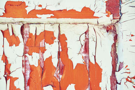 Old wooden background is painted in white, orange and brown color with cracks and scratches....