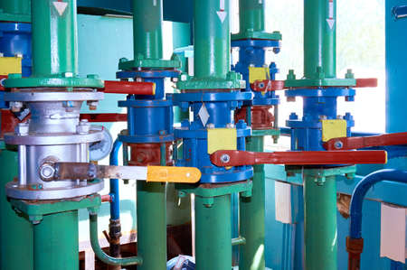 Several valves on the pipe painted green paint. Abstract background.