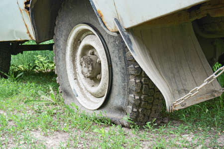 Flat tire on an old rusty SUV close-up. Abstract background.の写真素材