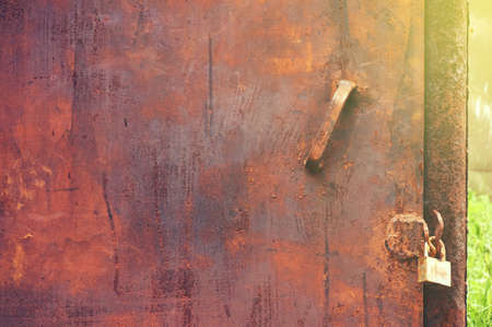 Old dirty rusty metal door with a lock. Abstract background.