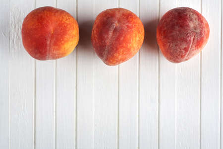 Delicious peaches on a white wooden background. Food background.の写真素材