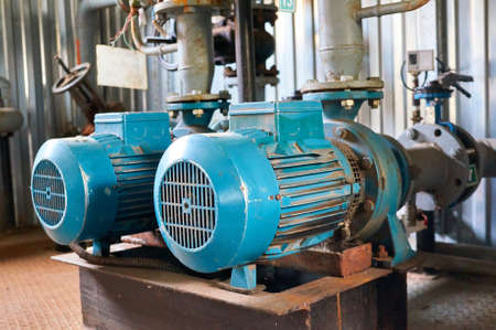 Old blue electric motor to the pump, valve and pressure gauge on the pipeline. Industrial...