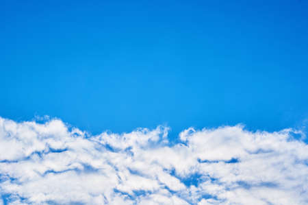 Saturated blue sky with clouds below.の写真素材