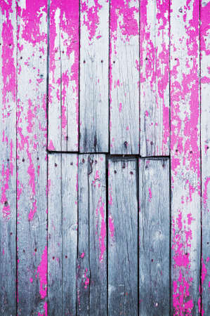 Old cracked wooden board painted with pink paint. Abstract background.の写真素材