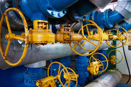 Valve with yellow helm on the pipeline.