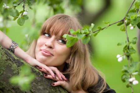 Girl s face and apple-tree flowers on a green backgroundの写真素材