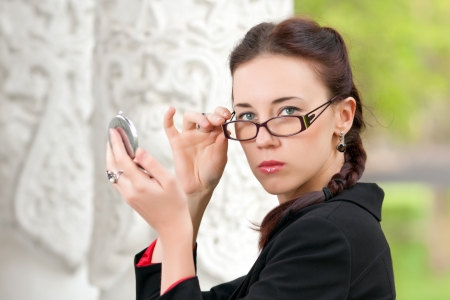 The girl wearing spectacles and a pocket mirrorの写真素材