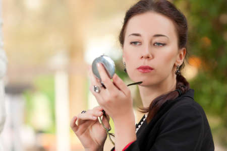 The woman looks in a pocket mirrorの写真素材