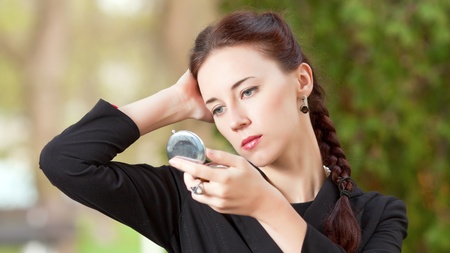 The woman looks in a pocket mirrorの写真素材