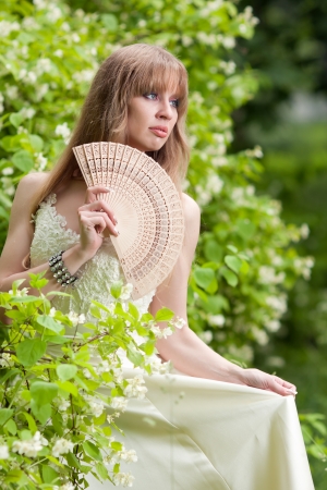 The girl with a fan in a white dressの写真素材