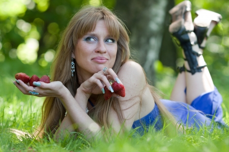 The woman in a grass and a strawberryの写真素材