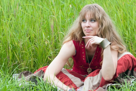   The dreaming girl of hippie sits on a grass  の写真素材