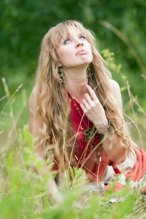 The girl of hippie sits in a green grassの写真素材