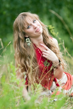 The girl of hippie sits in a green grassの写真素材