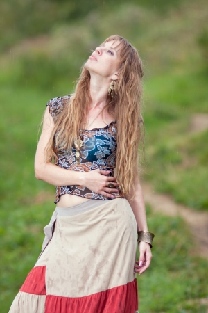 The girl of hippie costs in the rain in a long skirtの写真素材