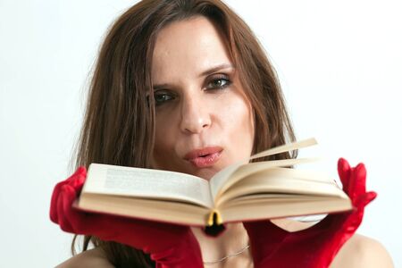 The beautiful woman holds the book near the face  の写真素材